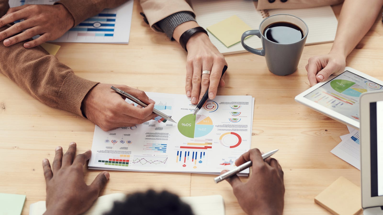 Hands reviewing marketing analytics and campaign reports at a table